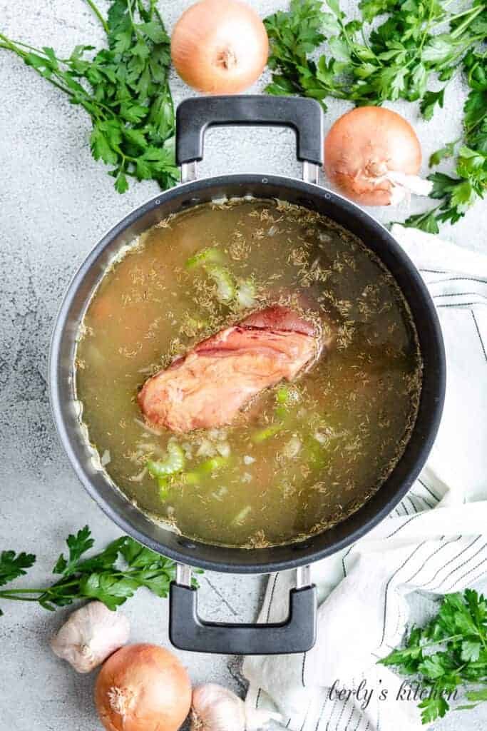 The soup broth starting to simmer in the pot.