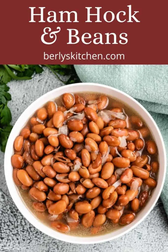 An aerial view of pinto beans and ham hocks in a bowl.
