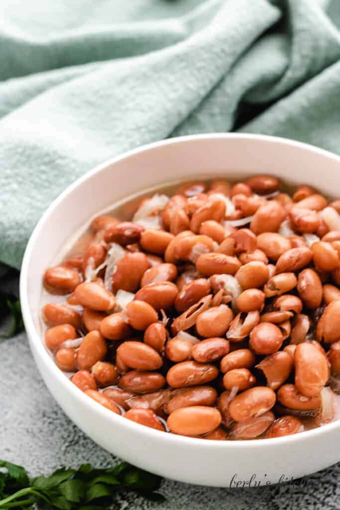 Ham and beans served in simple white bowl.