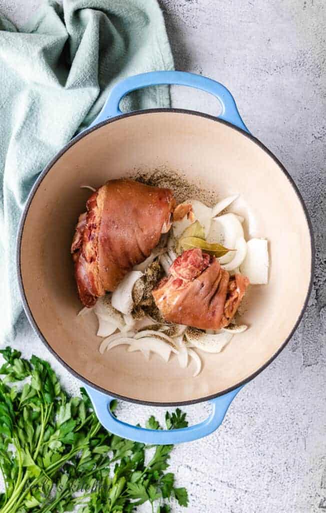 Pork, onions, and other ingredients in a pot.