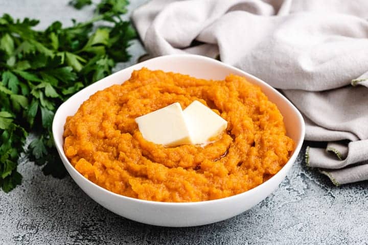 A white bowl loaded with Instant Pot mashed sweet potatoes.