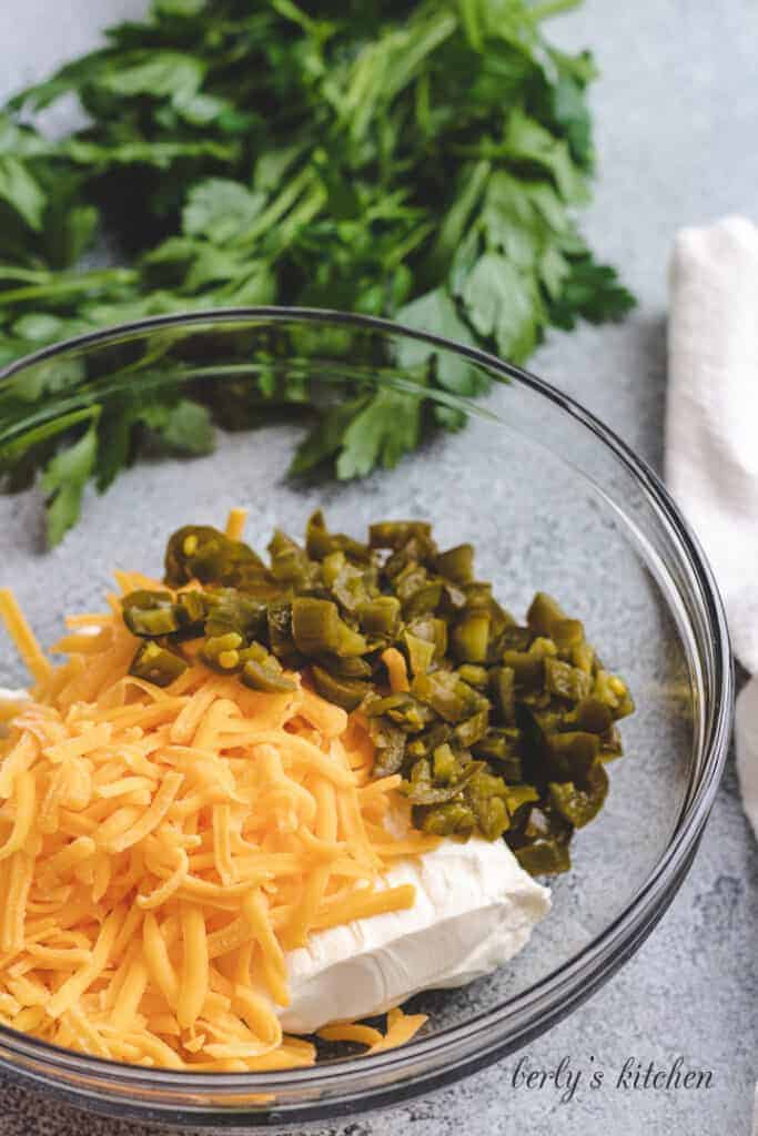 Peppers, cheddar, and cream cheese in a bowl.