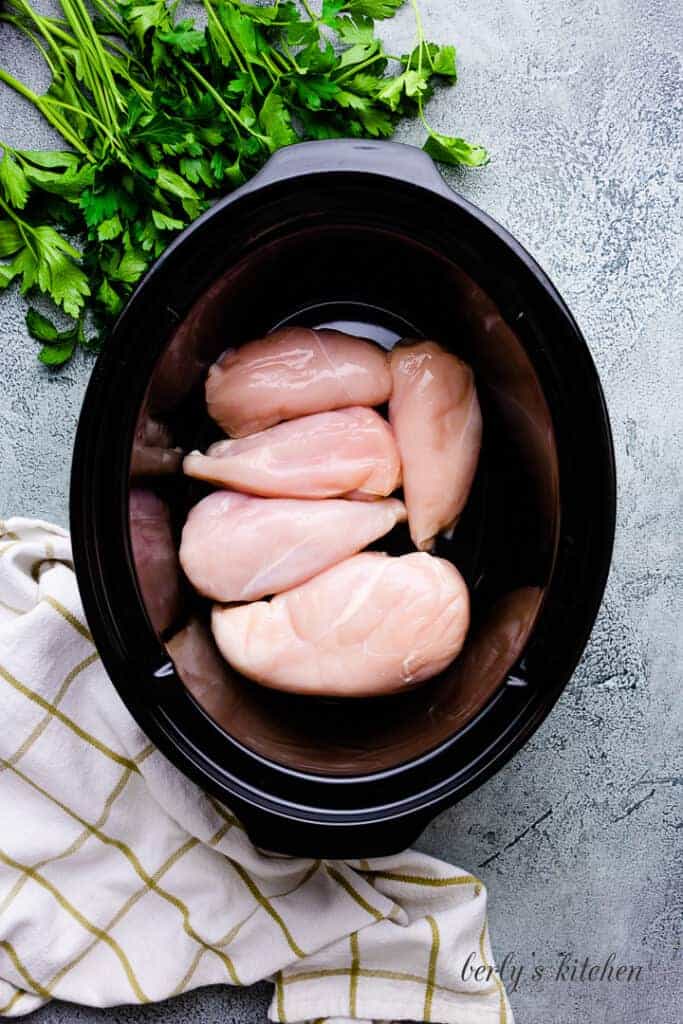 Raw chicken breasts in a crock pot.