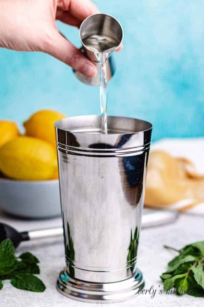 Simple syrup pouring into a shaker cup.
