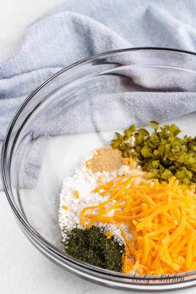 Pickles, baking mix, and other ingredients in a bowl.