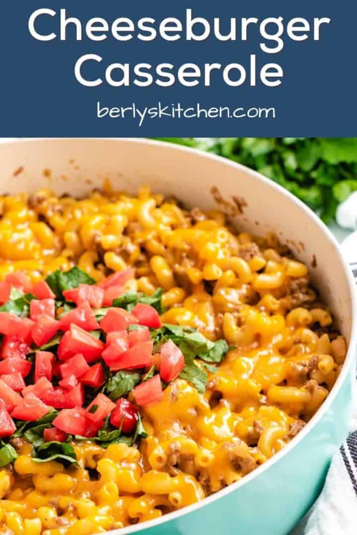 The cheeseburger casserole in the pan topped with diced tomatoes.