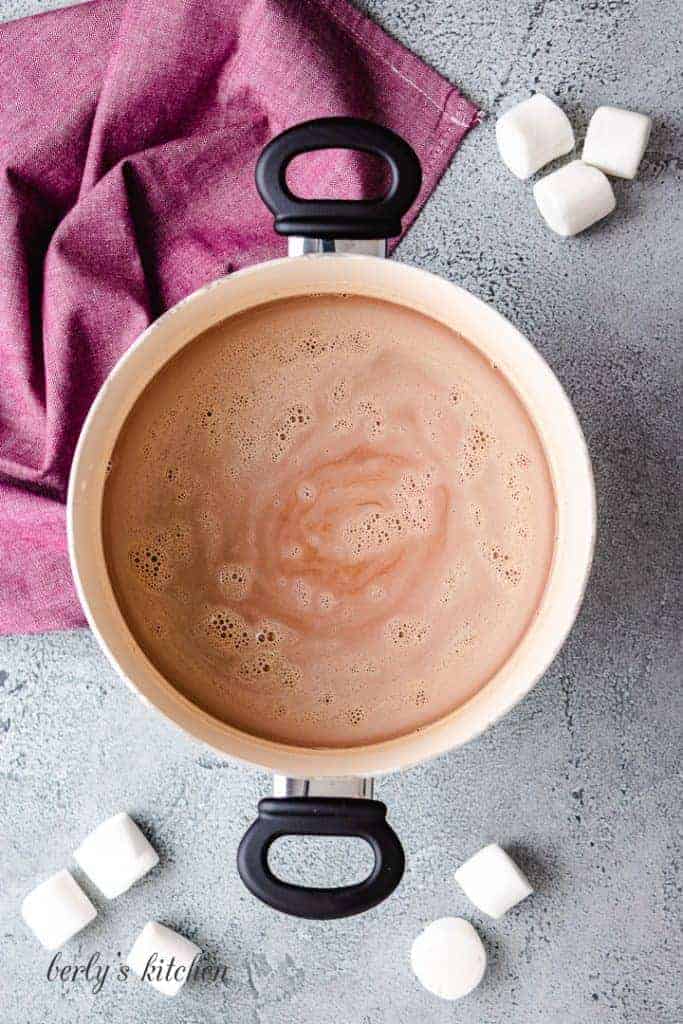 The hot cocoa simmering in the saucepan.