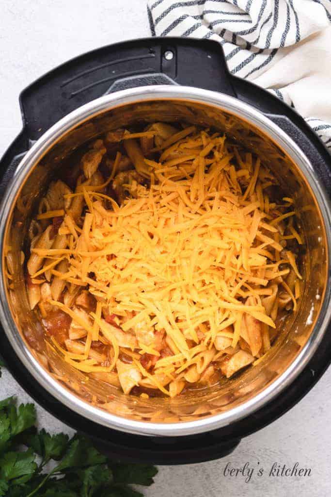 Shredded cheese added to the hot pasta.