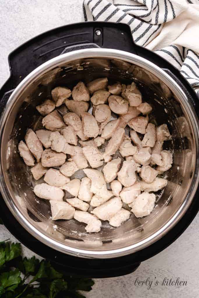 Chopped chicken cooking in the pressure cooker.