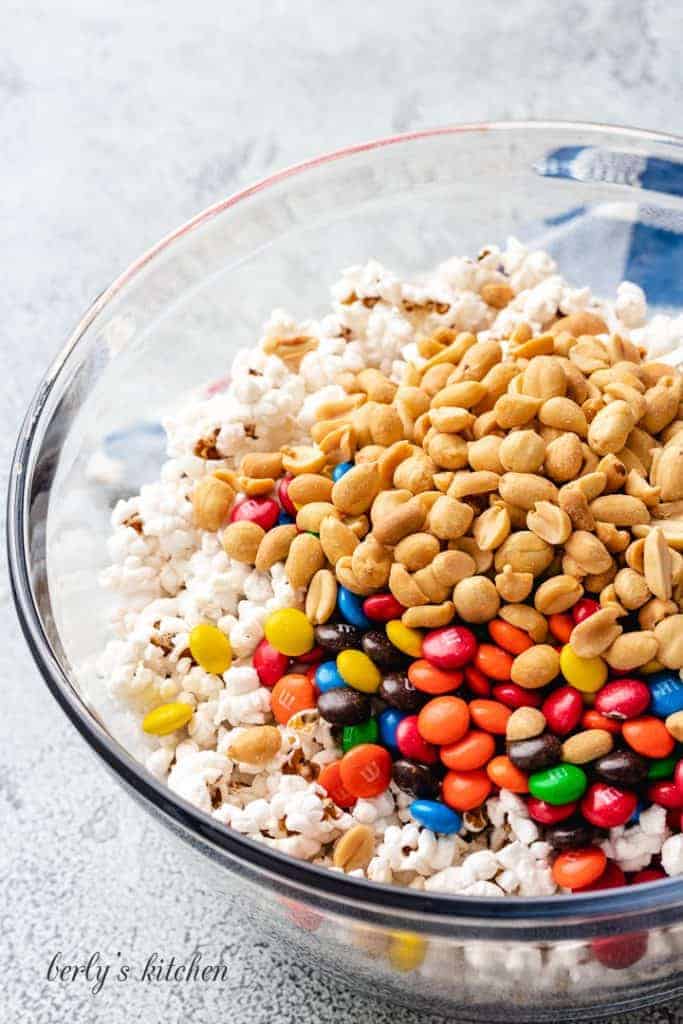 Peanuts, chocolate candies, and popcorn in a bowl.