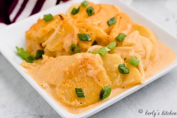 The scalloped potatoes topped with sliced green onions.