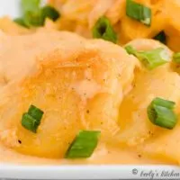 Creamy scalloped potatoes garnished with green onions.