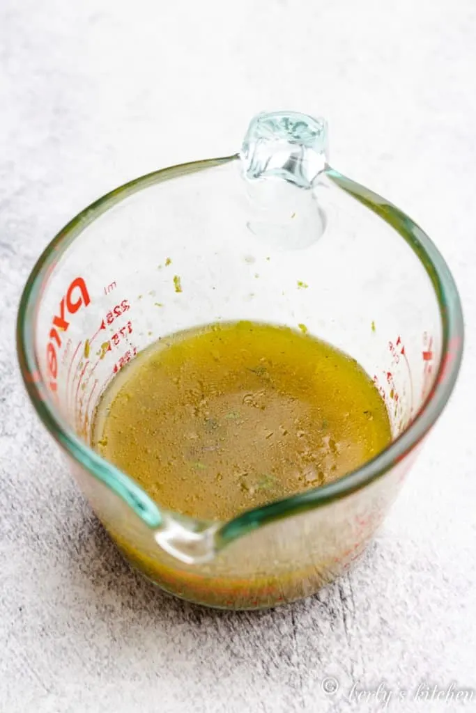 Lemon juice, zest, and other ingredients in a glass measuring cup.
