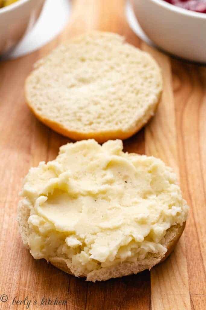 Mashed potatoes spread out on a bun.