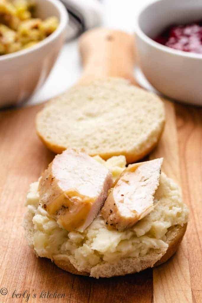Sliced turkey place on top of the mashed potatoes.