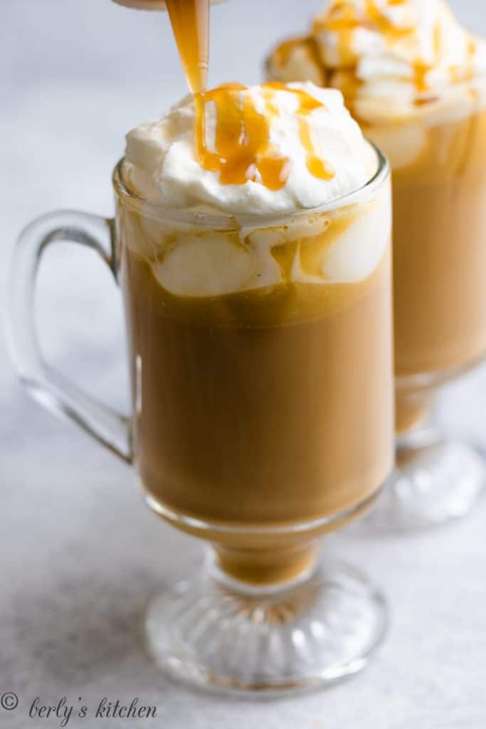 Butterscotch sauce being drizzled over whipped cream.