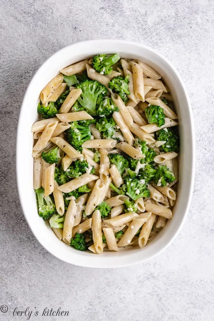 The noodles, veggies, and sauce combined in a casserole dish.