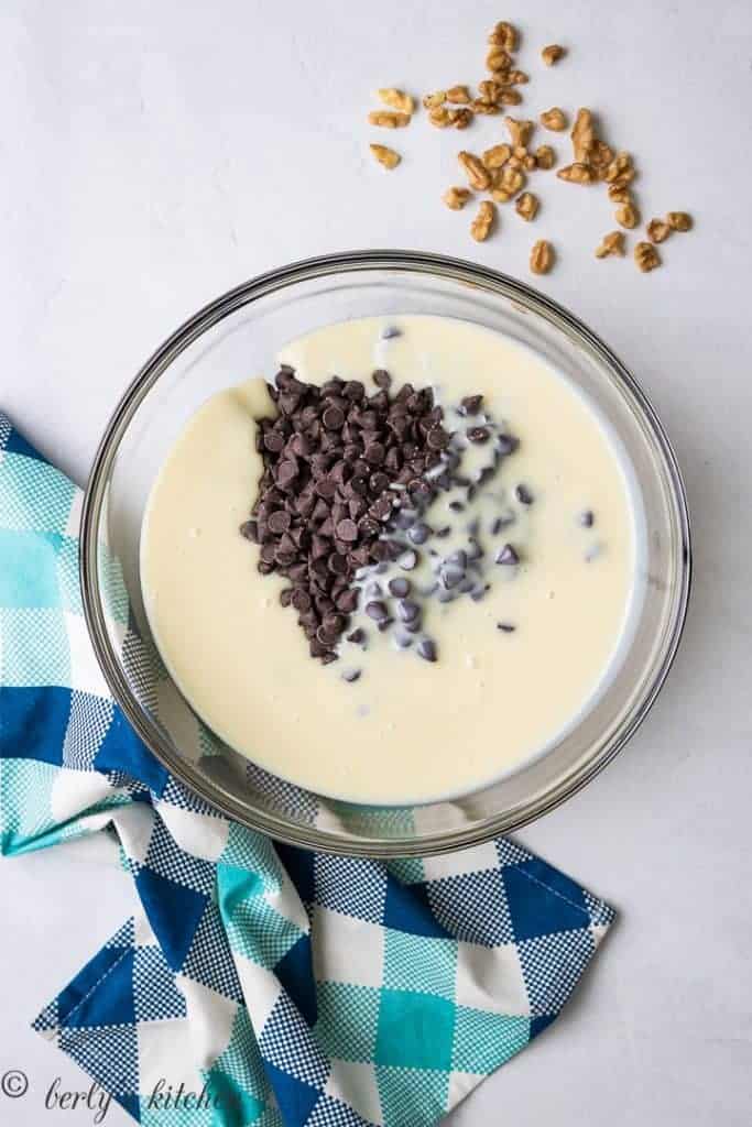 Sweetened condensed milk and chocolate chips in a heat-safe bowl.
