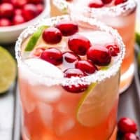 Cranberry margaritas in glasses garnished with fresh cranberries.