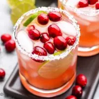 A cranberry margarita garnished with salt and fresh cranberries.