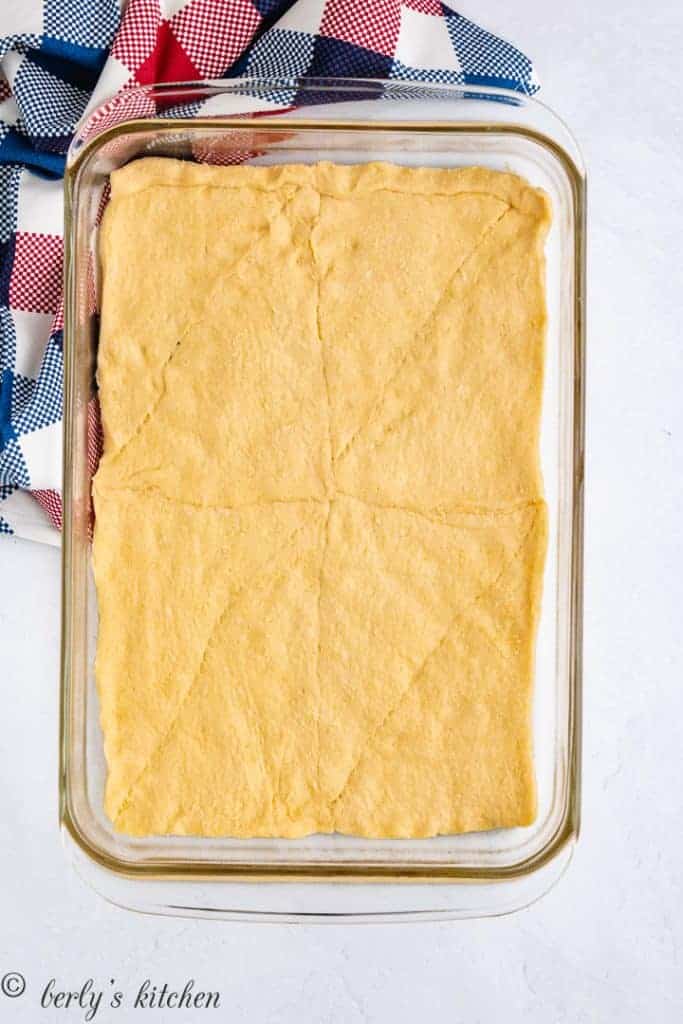 Crescent roll dough pressed into a large baking dish.
