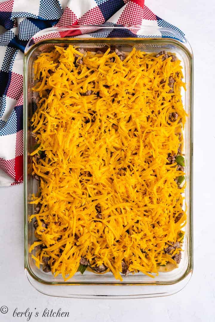 The sausage mixture and cheese layered into the dish.
