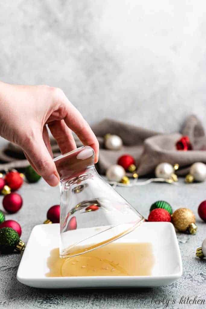 Eggnog Martini A martini glass rim being dipped into maple syrup.