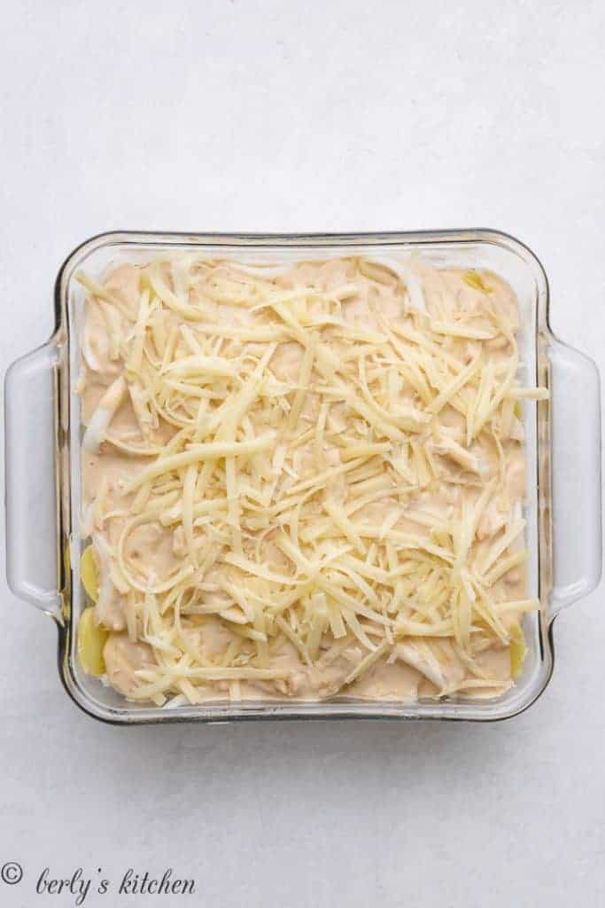The casserole topped with shredded Gruyere cheese.