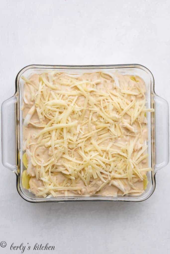 The casserole topped with shredded Gruyere cheese.