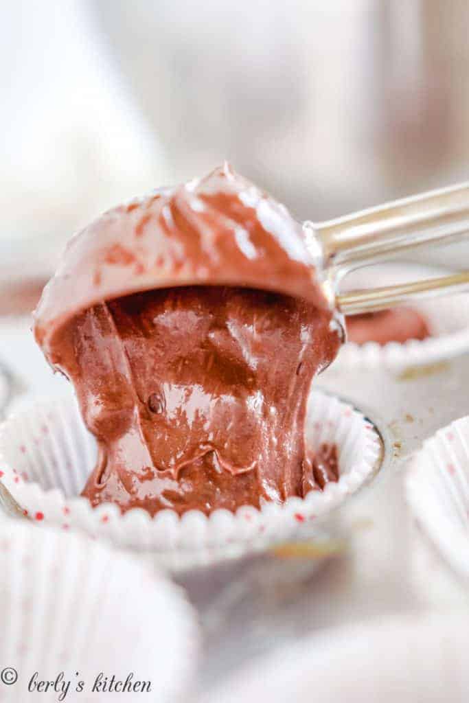 Cupcake batter being added to a cupcake liner.