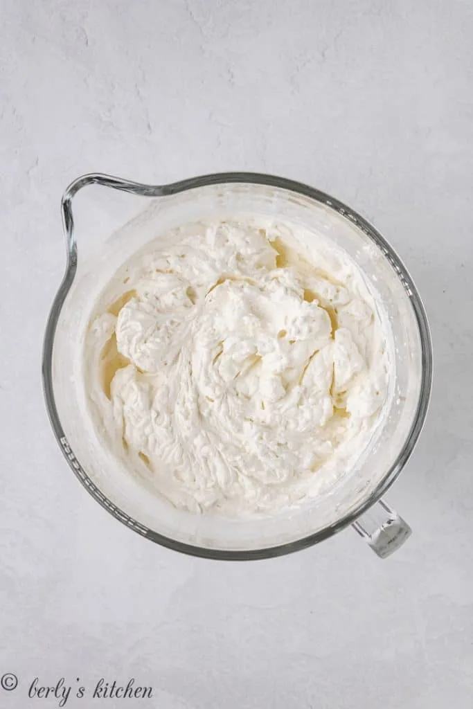 Whipped cream in a large mixing bowl.