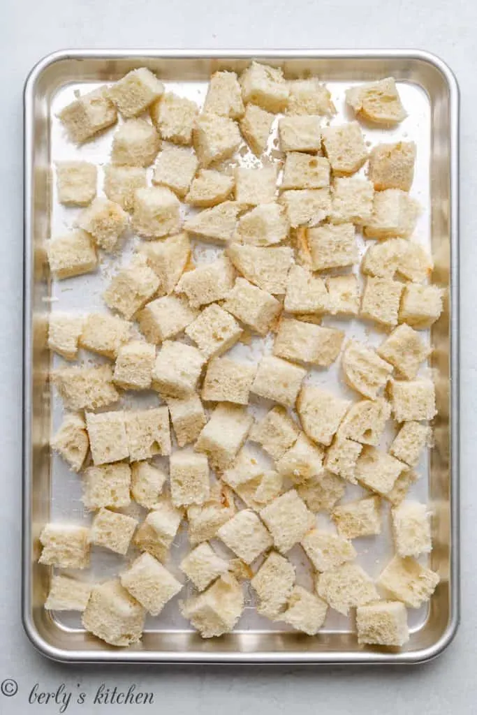 Cubes of French bread on a sheet pan.