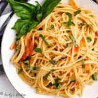 Top-down view of the tomato basil pasta garnished with fresh herbs.