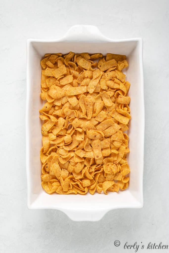 Corn chips layered into a baking dish.