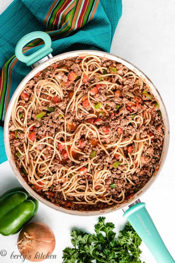 Spaghetti and meat cooking in a pan.