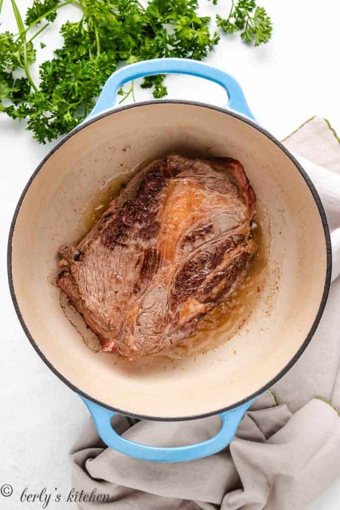 Seared chuck roast in a Dutch oven.