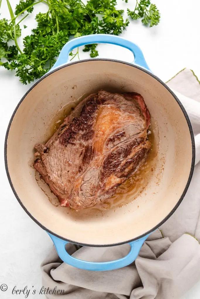 Seared chuck roast in a Dutch oven.