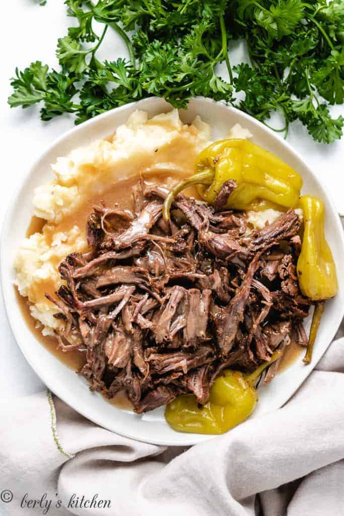 Pot roast and mashed potatoes with pepperoncinis.