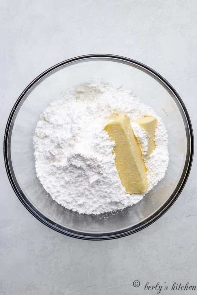 Powdered sugar and butter in a mixing bowl.