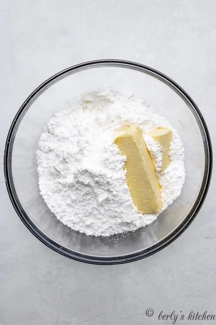 Powdered sugar and butter in a mixing bowl.