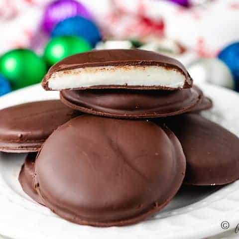 A pile of peppermint patties on a white plate.