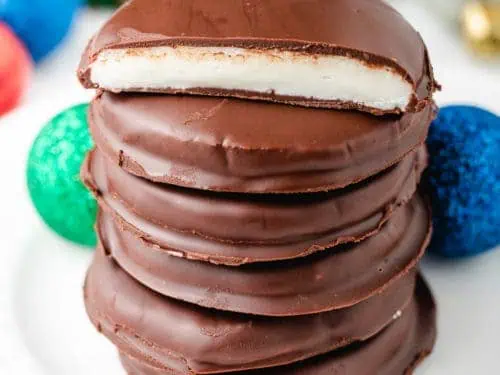 Six peppermint patties stacked on a plate.