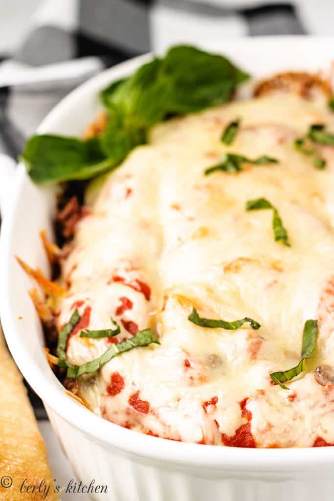 The cheesy pasta casserole topped with fresh basil.
