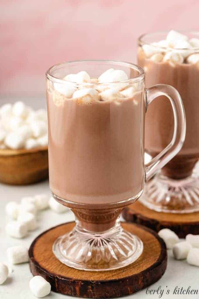 A glass mug filled with the hot cocoa.