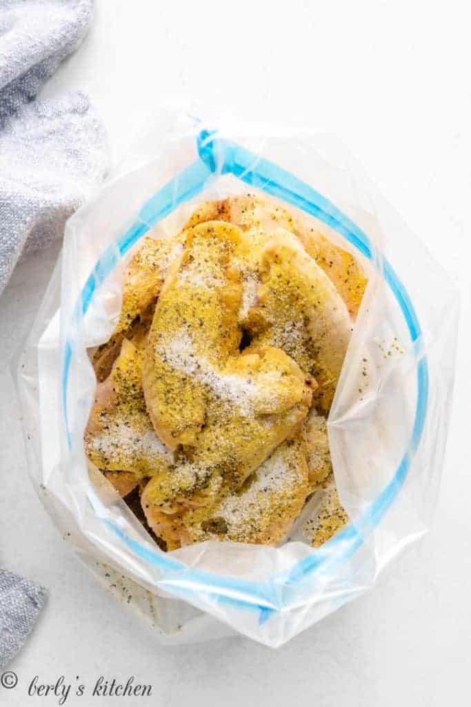 Chicken wings in an open plastic bag.