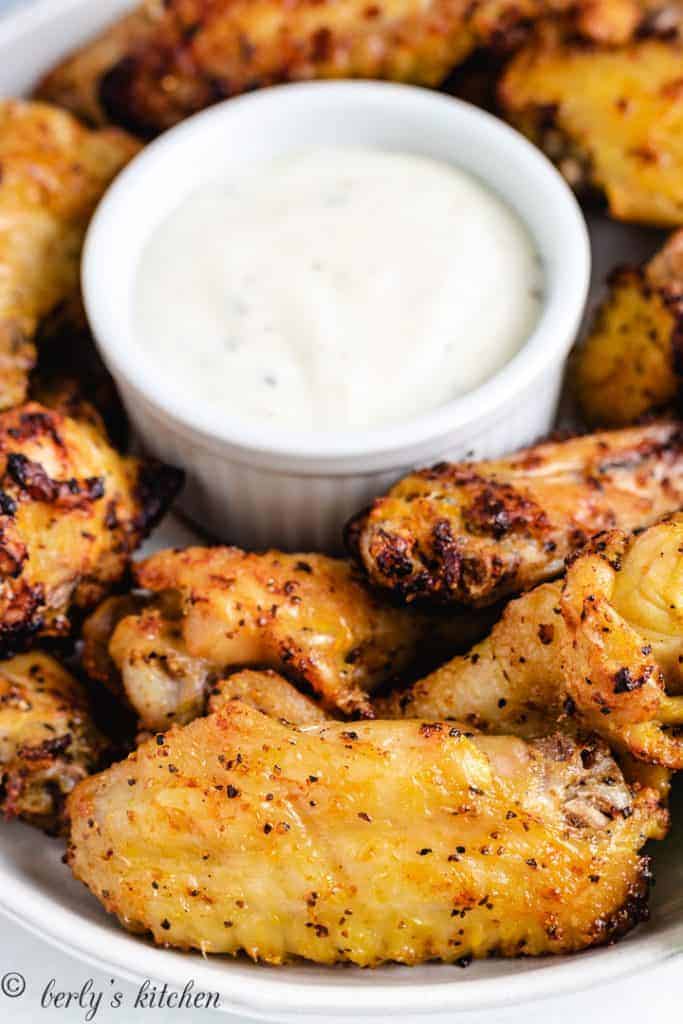 A plate of chicken wings and ranch dressing.