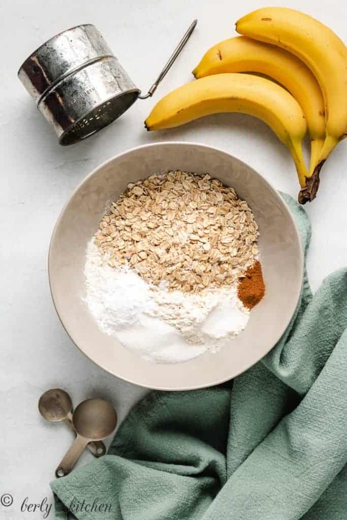 Oats, flour, and spices for pancakes in a gray bowl.