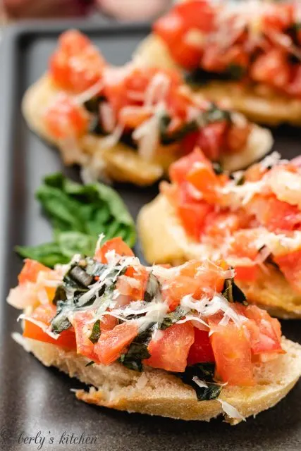 Up close photo of several slices of bruschetta on toast.