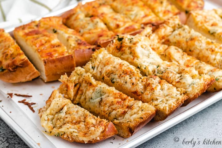 Garlic bread with melted cheese on a pan.