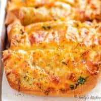 Cheesy garlic bread slices on a pan.